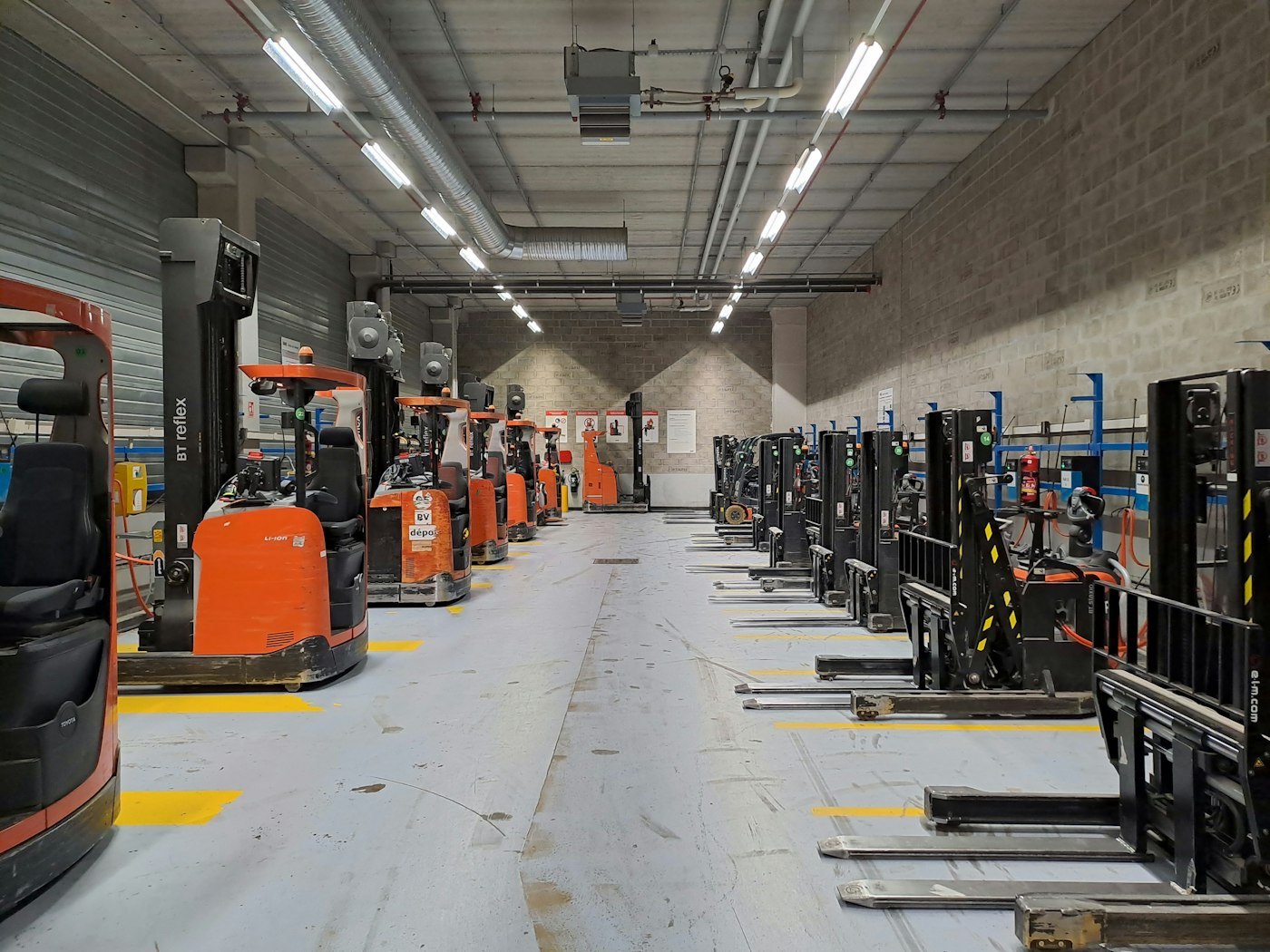 Forkliftler ve iş makineleriyle dolu geniş depo: Ekipman Yönetimi modülü ile envanter ve ekipman kaydı